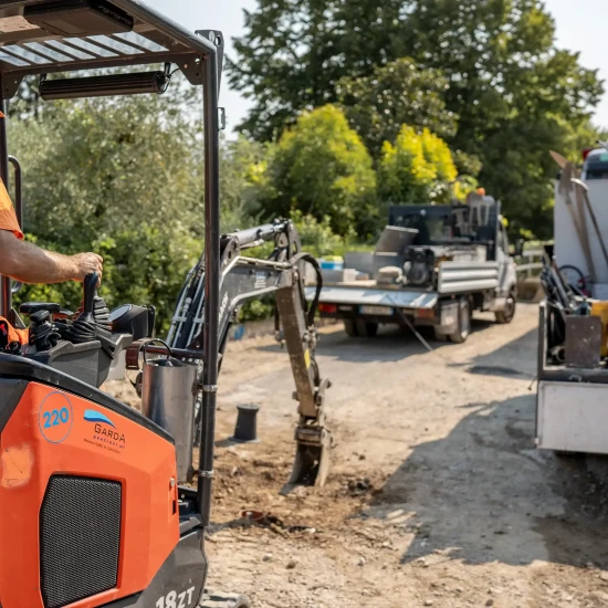 Operatore su mini escavatore al lavoro in un cantiere stradale