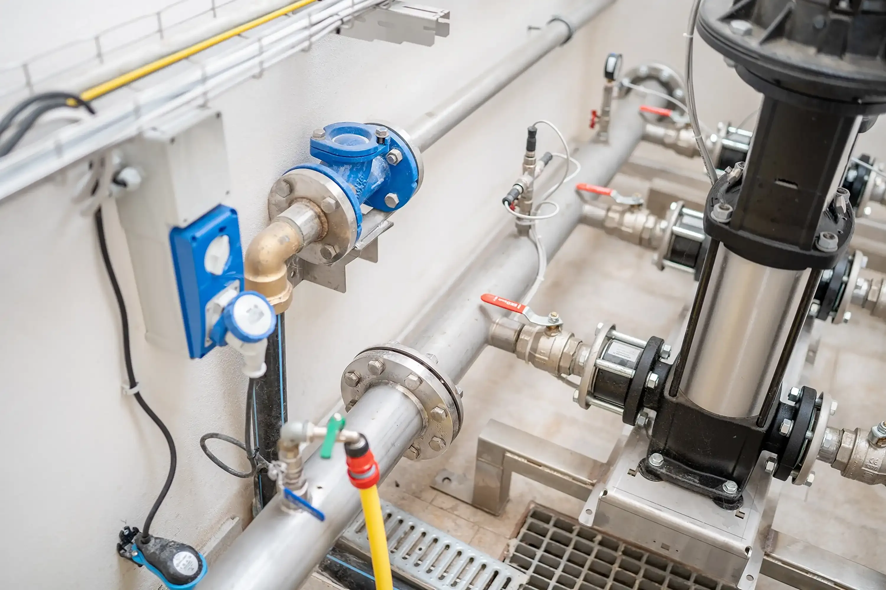 Dettaglio di impianto idraulico industriale con raccordi e valvole