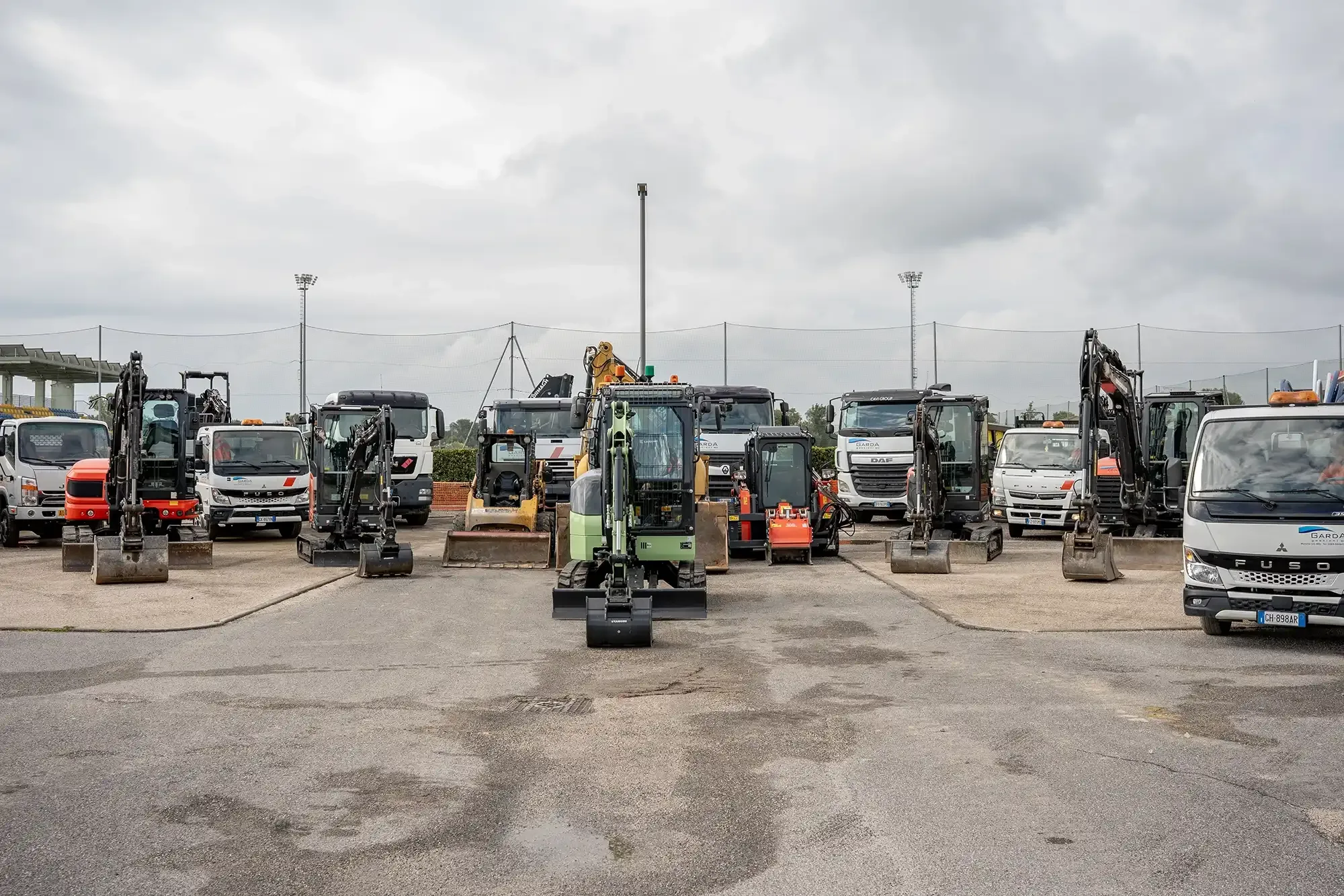 Macchine movimento terra e camion parcheggiati in un'area industriale